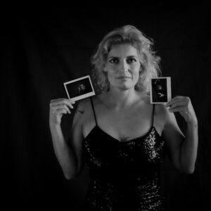 Une femme qui présente deux polaroids